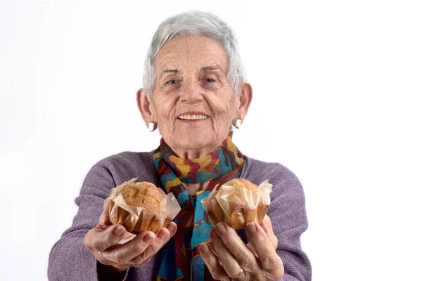 Senior vrouw eten cupcak — Stockfoto