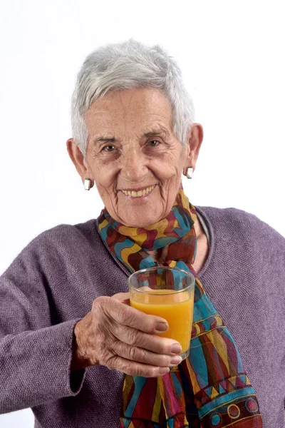 Senior Kvinna dricka saft på vit bakgrund — Stockfoto