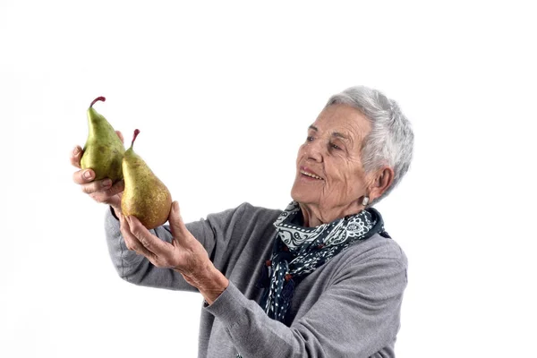 Senior Kvinna äta päron på vit — Stockfoto