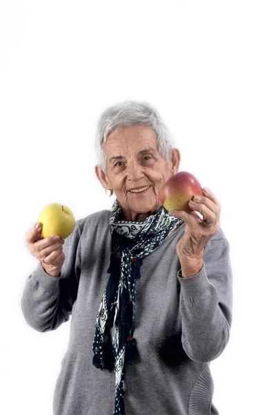 Senior woman eten apple op wit — Stockfoto