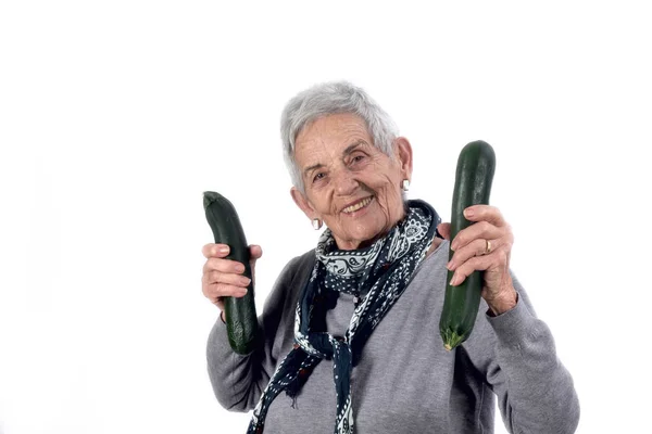 Senior kvinna som spelar zucchini; på vit — Stockfoto