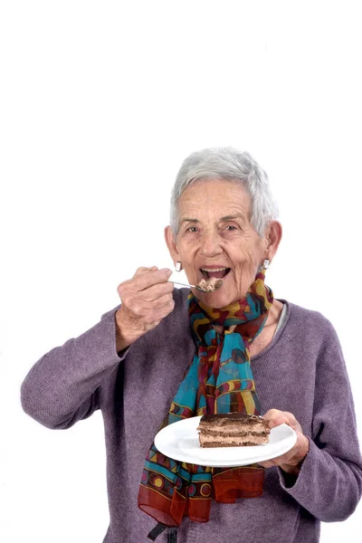 Older woman eating a piece of cake — Stock Photo, Image