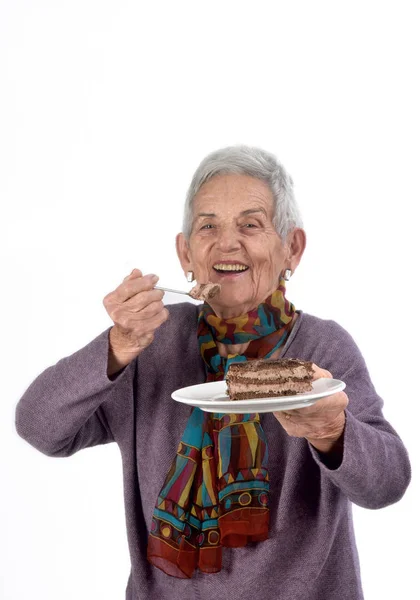 Older woman eating a piece of cake — Stock Photo, Image