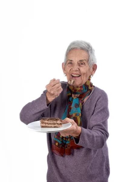 Older woman eating a piece of cake — Stock Photo, Image