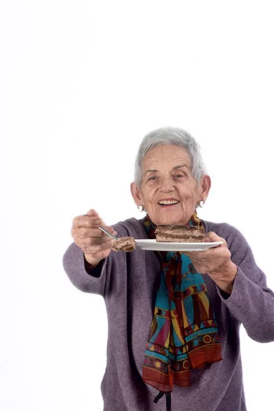 Yaşlı kadın bir dilim pasta yemek — Stok fotoğraf