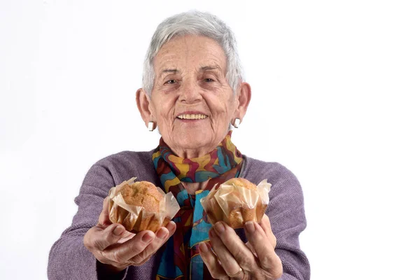 Mulher idosa comendo cupcak — Fotografia de Stock