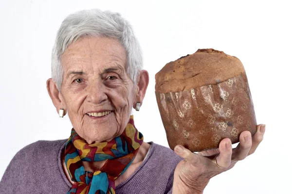 Oudere vrouw panettone eten op witte achtergrond — Stockfoto
