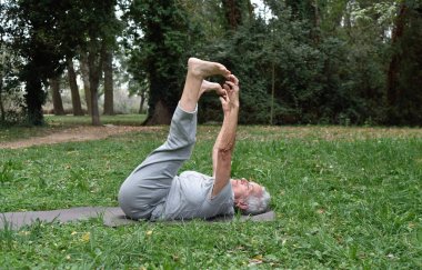 yaşlı kadın pratik yoga açık havada