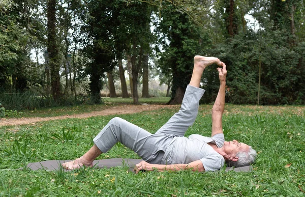 Starsza kobieta praktykowania jogi na zewnątrz. — Zdjęcie stockowe