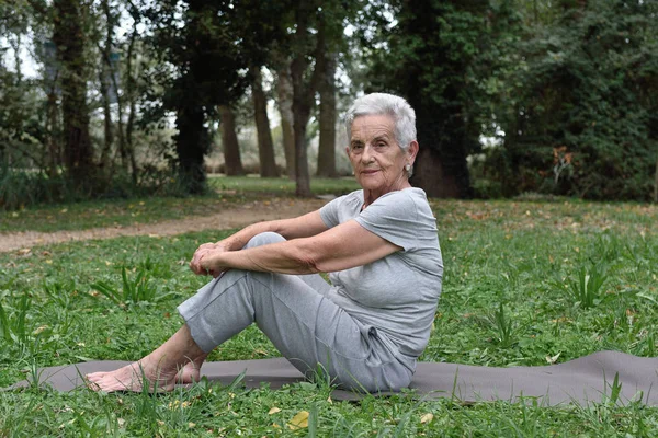 Bejaarde vrouw praktizerende yoga buiten — Stockfoto