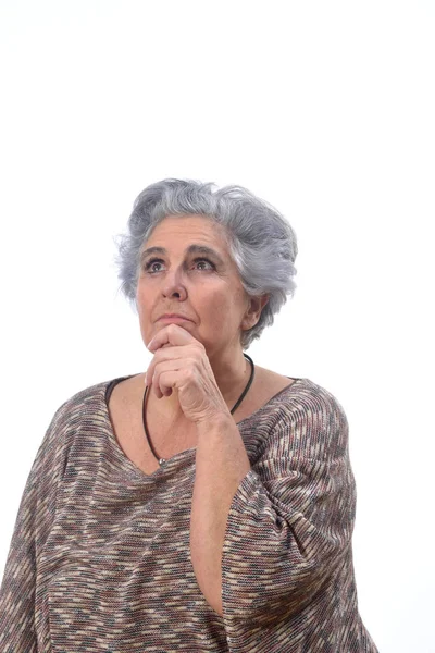 Вдумчивая пожилая женщина на белом фоне — стоковое фото