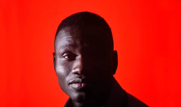 Portrét africké muže se na červeném pozadí zavřenýma očima — Stock fotografie