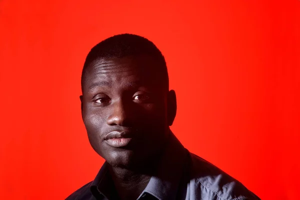 Portrait of a african man with eyes closed on red background — Stock Photo, Image