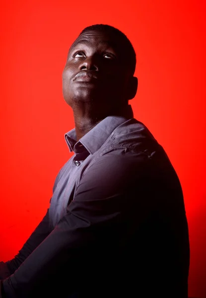 Gözleri kırmızı arka plan üzerinde kapalı olan Afrikalı bir adam portresi — Stok fotoğraf