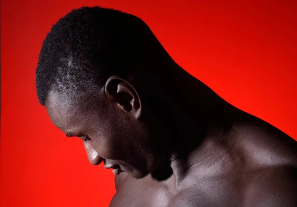 Ritratto di un uomo africano che guarda in basso sul rosso — Foto Stock