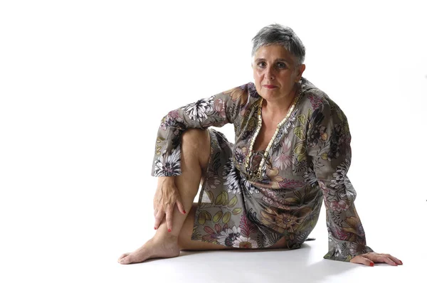 Retrato de uma mulher idosa sentada no chão — Fotografia de Stock