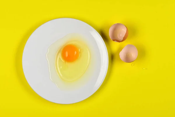Треснувшее яйцо на желтом фоне — стоковое фото