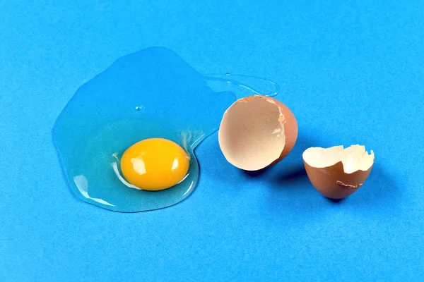 Huevo agrietado sobre fondo azul — Foto de Stock