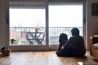 oturma ve onun köpeği ile pencereden dışarı bakarak üzgün kadın