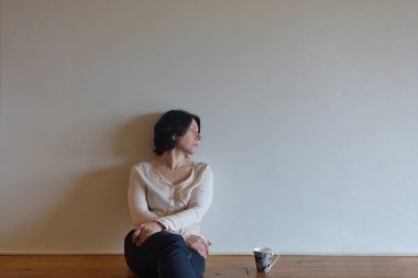 üzgün bir kadın evinin ahşap zemin üzerinde