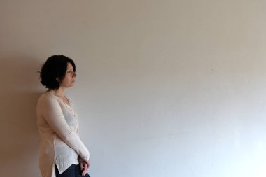 üzücü bir kadın ayakta ve duvara çarptı