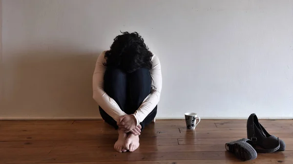 Smutná žena na podlaze svého domu — Stock fotografie
