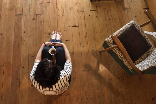 Mulher sentada no chão de madeira — Fotografia de Stock
