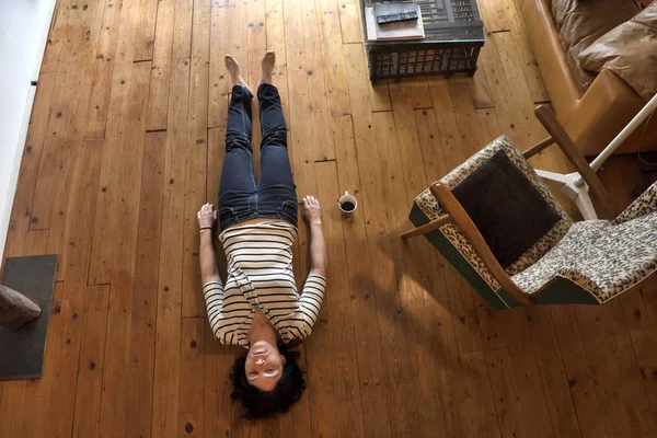 Uma mulher deitada no chão de sua casa — Fotografia de Stock