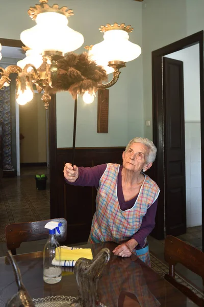 Sênior mulher espanando a casa — Fotografia de Stock