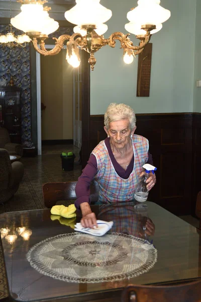 Sênior mulher espanando a casa — Fotografia de Stock