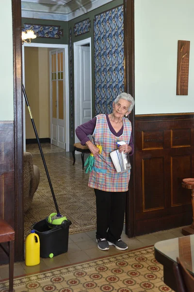 Porträtt av en äldre kvinna kommer för att göra rengöring hemma — Stockfoto