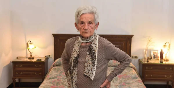 Portrait of an elderly woman in a bedroom — Stock Photo, Image