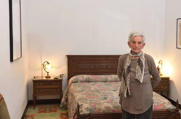 Portrait of an elderly woman in a bedroom — Stock Photo, Image