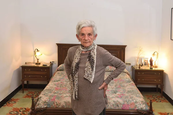 Retrato de uma mulher idosa em um quarto — Fotografia de Stock