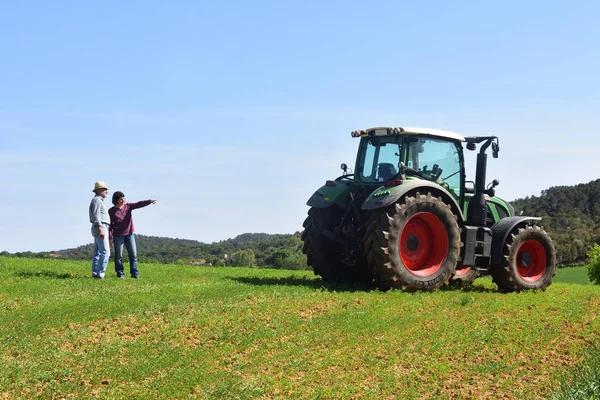 Paar van boeren in een veld met een trekker — Stockfoto