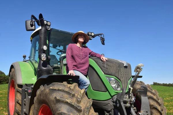 Potret seorang wanita petani dan traktor di lapangan — Stok Foto