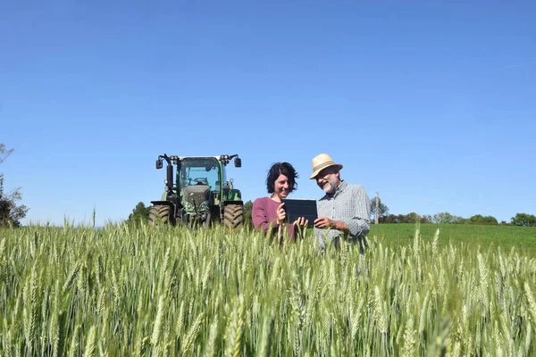 Bauernpaar auf einem Feld mit digitalem Tablet — Stockfoto