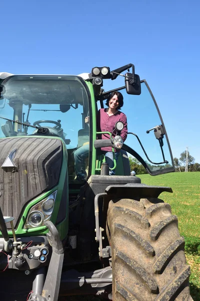 Retrato de uma mulher agricultora e trator — Fotografia de Stock