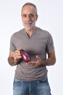 Beyaz arka planda patlıcan taşıyan bir adamın portresi.