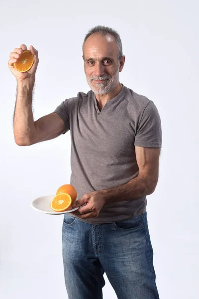 Hombre con fruta naranja sobre fondo blanco — Foto de Stock