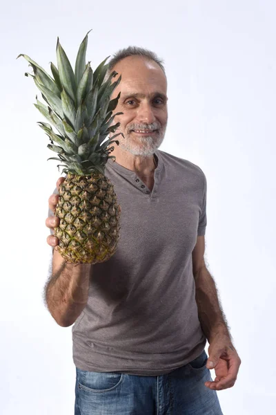 Uomo con ananas su sfondo bianco — Foto Stock