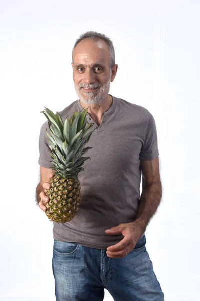Людина з ананасом на білому тлі — стокове фото
