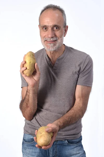 Retrato de um homem com batatas no fundo branco — Fotografia de Stock