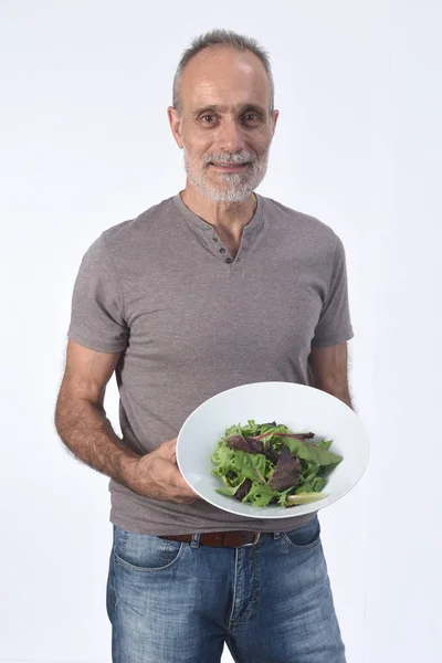 Homem com salada no fundo branco — Fotografia de Stock