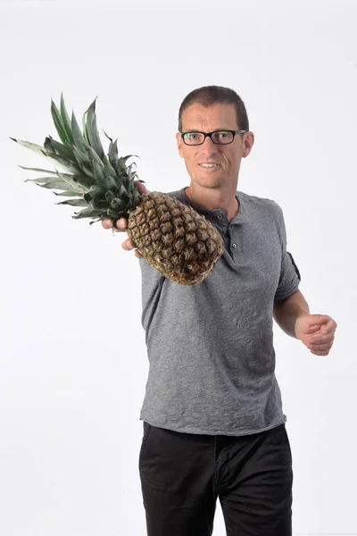 Muž s ananasem na bílém pozadí — Stock fotografie