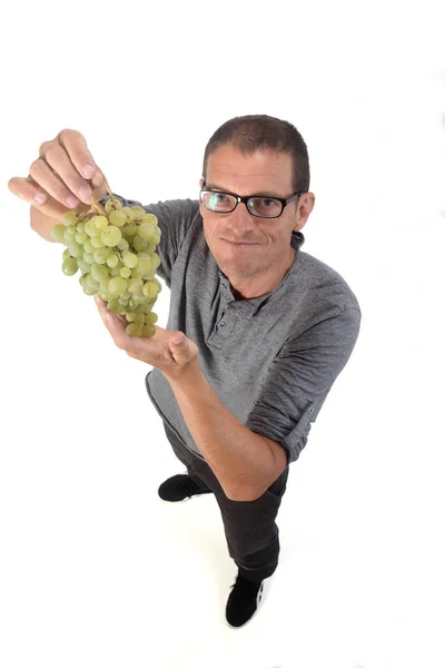 Homem com fruta de uva no fundo branco — Fotografia de Stock