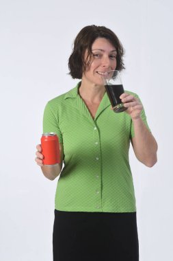 Beyaz arka planda bir bardak kola içen kadın.