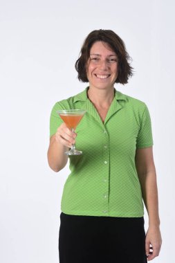 Beyaz arka planda bir bardak kokteyl içen kadın.