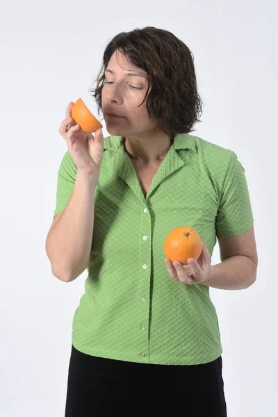 Donna con frutta arancione su sfondo bianco — Foto Stock