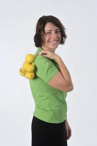 Mulher com frutas de limão em fundo branco — Fotografia de Stock